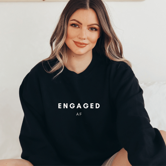 Engaged AF sweatshirts  This sweatshirt makes a wonderful engagement announcement or gift.  Warm and cozy sweatshirts. True to fit sizing. (Size up for the oversized look). Unisex  sizing so suitable for men and women.  6 colours - Sand, White, Black, Grey, Pink or Navy 
