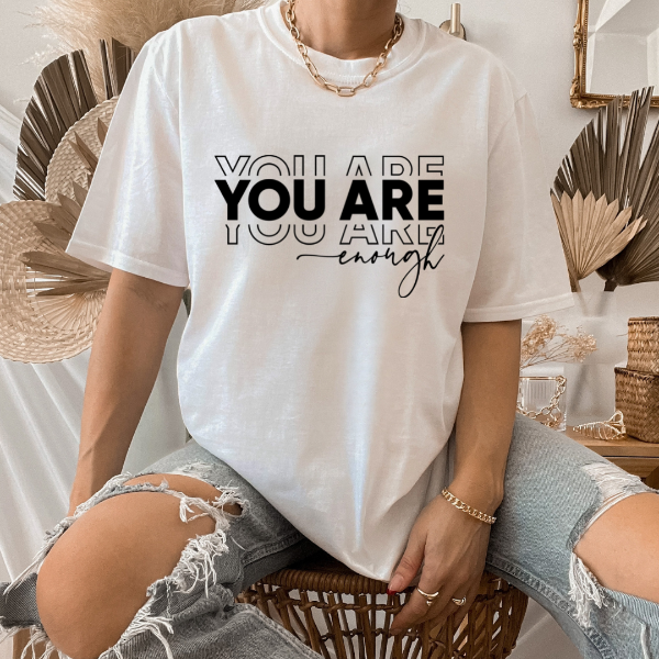 You are enough  Our Tees are soft & Comfortable to help you feel cozy and relaxed. They come in several colours and true to fit sizes. (Go up a size for a more oversized, relaxed fit)  Unisex T-shirts - suitable for men and women.  Colours available - White, Black, Indigo Blue, Military Green, Sand, Natural, Navy, Red, or Grey Tee
